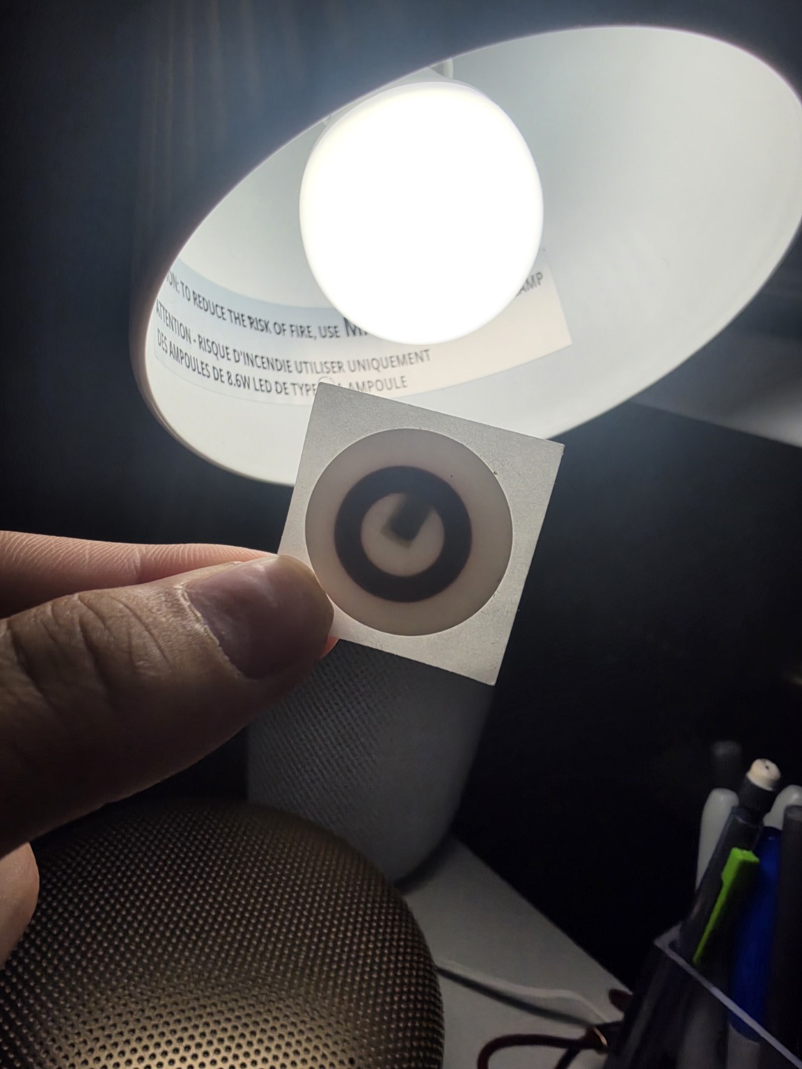 A person holding a round sticker fob for a demonstration
